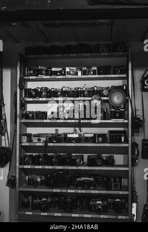 BUCHAREST, ROMANIA - Aug 25, 2021: A beautiful grayscale shot of a collection of old cameras on a shelf Stock Photo