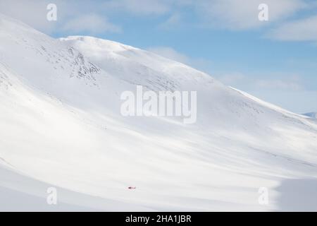 A helicopter that has just brought a couple of alpine skiers to Tjaktja pass, Kungsleden trail, Sweden, winter season, April Stock Photo