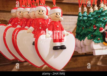 Cute ceramic souvenirs at the christmas fair market. Showcase with hanging christmas tree decorations. Christmas sale and New Year gift shopping.  Stock Photo