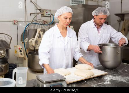 Woman preparing formed dough for proofing Stock Photo