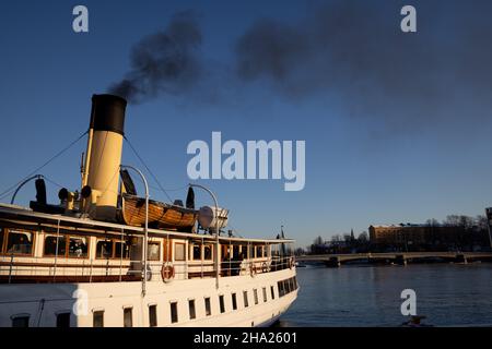 Air pollution in Stockholm. Chimney of boat with black smoke coming out of it. Climate change and carbon emission theme. Stock Photo