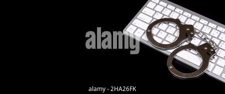 Keyboard and handcuffs with LED lights on. Cybercrime concept Stock Photo