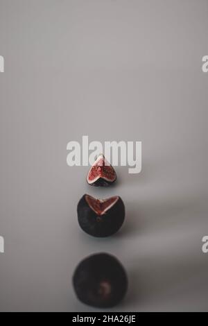 Line of figs from the whole one to a half and a piece of fig. Top view of figs Stock Photo