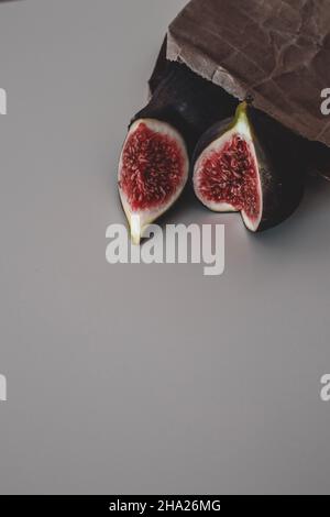 Fresh fruit harvest of ripe figs whole and halved, on the brown craft paper Stock Photo