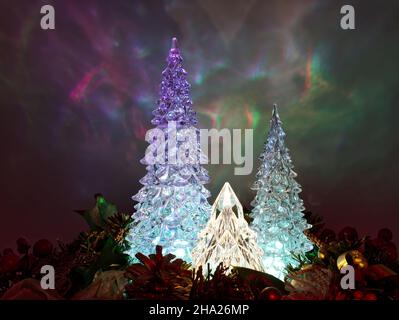 Illuminated Christmas Trees isolated on colorful blurred background. Stock Photo