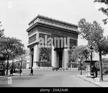 Paris Arc de triomphe with horse-drawn wagon loaded with barrels during World War II. A view of the circular Place de l'Étoile taken from Avenue Marceau near the end of World War II.  There are two kiosks promoting the Loterie Nationale. The image depicts period street lights and trees showing early spring foliage. Stock Photo