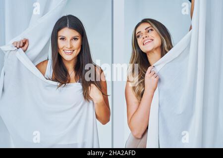 Two girl friends in clothes store in changing room Stock Photo