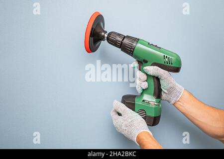 grinding wall or paint removal with disc sanding hand machine. Worker labor and equipment concept Stock Photo