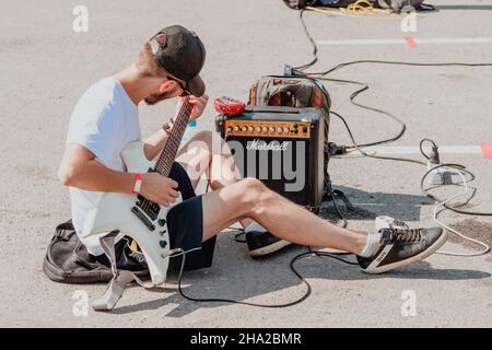 21 August 2021, Ufa, Russia: A street guitarist tunes up a Marshall guitar amp before performing. Sound check and equipment Stock Photo