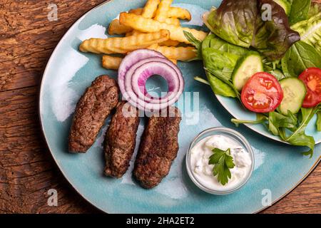 cevapcici with french fries and salad Stock Photo
