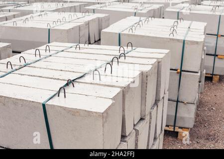 A lot of building cement blocks in an extensive open-air warehouse. Construction of curbs and pavement in the city Stock Photo