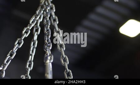 punching bag hanging in the gym on the chains. Punching bag chain. Stock Photo