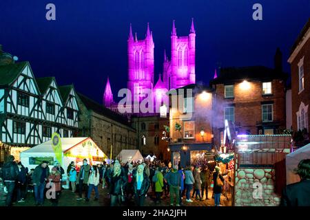 Lincoln Cathedral is floodlit for the annual Christmas market. Visitors pack the maarket between the Cathedral and the castle..The market returning after being cancelled the previous year due to Covid 19 is one of the largest Christmas markets in Europe. Centred in and around the catle and the Cathedral in the Bailgate area of Lincoln the markets draws visitors from all over Europe. Stock Photo