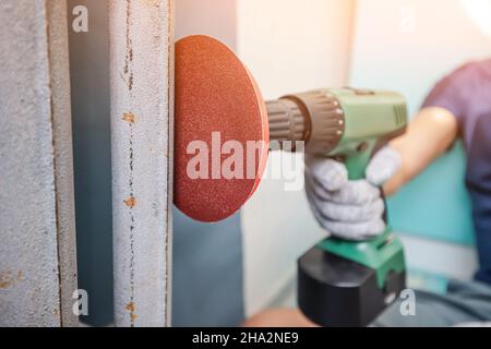 grinding wall or paint removal with disc sanding hand machine. Worker labor and equipment concept Stock Photo
