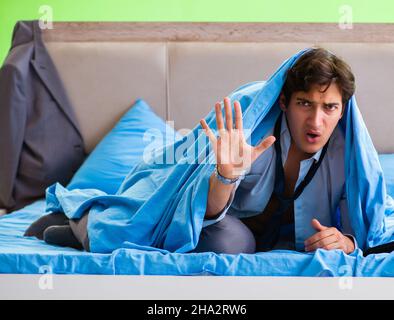 The employee in the bedroom being late for his job Stock Photo