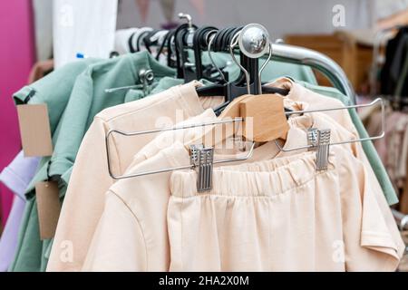 Fashionable casual clothes in pastel colors on a hanger in the store Stock Photo