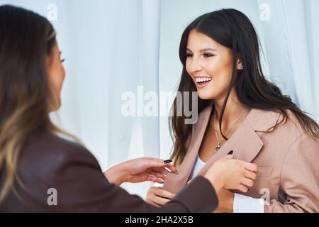 Two girl friends in clothes store in changing room Stock Photo