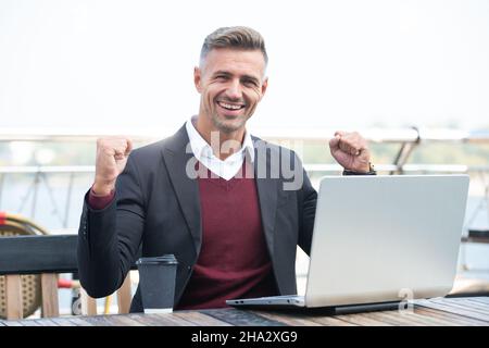 You can win. Happy businessman make winning gesture. Creating winning e-business Stock Photo