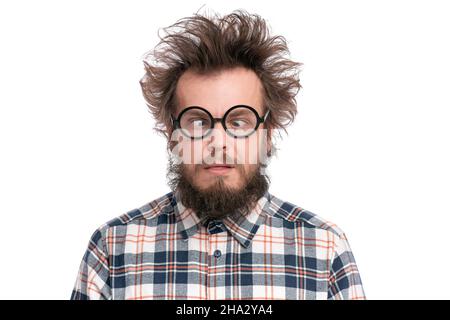 Crazy Bearded Man with funny Haircut in Eyeglasses making Grimace. Silly Guy in plaid shirt, isolated on white background. Emotions and signs concept Stock Photo