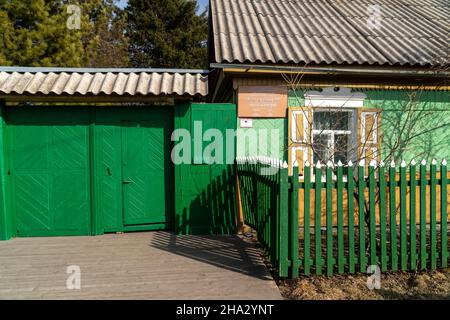 Wooden gates and a gate to the house-museum of the writer V.P. Astafiev with a memorial plaque at the entrance on a sunny spring day. Stock Photo