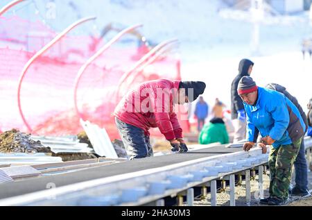 HOHHOT, CHINA - DECEMBER 10,2021 - Construction workers install ski equipment at The Manong Mountain ski Resort in Hohhot, North China's Inner Mongoli Stock Photo