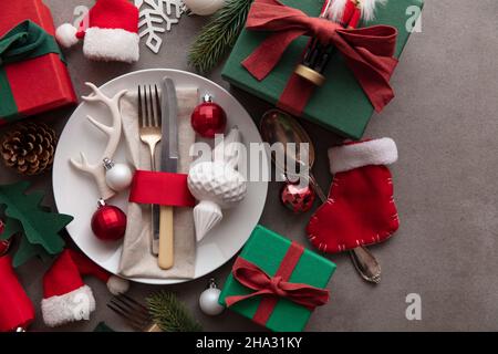 Festive Christmas meal background. Place setting with plate and cutlery surrounded by decorations decorations Stock Photo