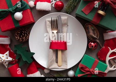 Festive Christmas meal background. Place setting with plate and cutlery surrounded by decorations decorations Stock Photo