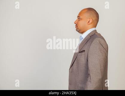 Young African American man standing looking to the side. Serious African man male, standing in profile, looking to the side, posing for a photo Stock Photo