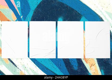 teal mint urban wall with four glued posters Stock Photo
