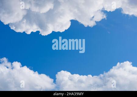 Fluffy white clouds on deep blue sky, frame with copy-space Stock Photo
