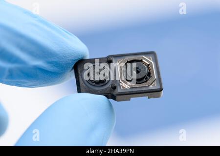 Smartphone dual camera system module in scientist hands Stock Photo