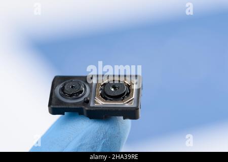 Smartphone dual camera system module on fingertip of hand in glove Stock Photo