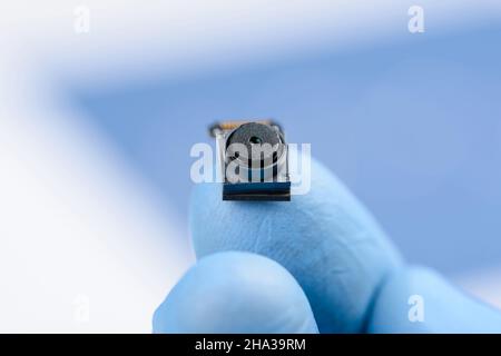 Smartphone front camera module on fingertip in laboratory, research or repair concept Stock Photo