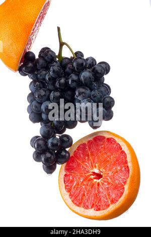 Dark blue grape with red grapefruit isolated on white background Stock Photo