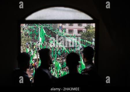 Gaza City, Palestinian Territories. 10th Dec, 2021. People look from a window on a mass rally marking the 34th anniversary of the founding of the Islamist movement Hamas. Credit: Mohammed Talatene/dpa/Alamy Live News Stock Photo