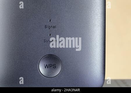 close-up with selective focus on WPS button and status lights on modern WiFi repeater or router . The device for extend range of wireless network serv Stock Photo