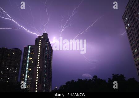 Spectacular Real Lightning Strikes in Dark Purple Urban Night Sky Stock Photo