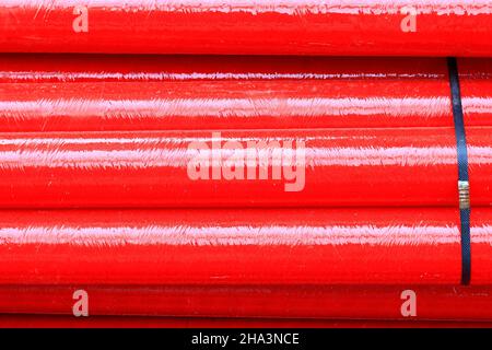 Red Fiberglass pipes at construction site, Corrosion resistant fiberglass composite pipe used in industrial applications. Stock Photo