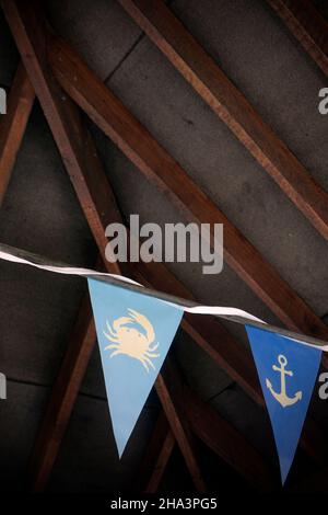 coloured bunting flags in rafters of barn Stock Photo