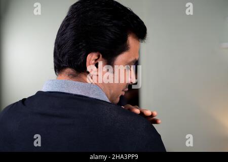 Young man worry about falling dandruff on shoulder while getting ready or setting hairstyle - concept Hair care or hair loss and scalp treatment Stock Photo
