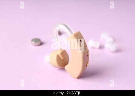 Concept of health care with hearing aid on purple background Stock Photo