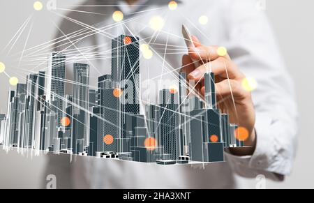 Businessman hovering a modern cityscape floating on his hand Stock Photo