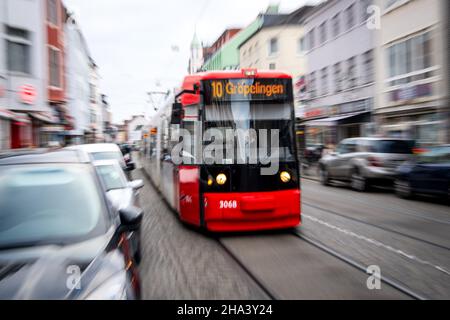 Bremen, Germany. 10th Dec, 2021. A tram travels between cars through the city centre. The transport ministers of the federal states have met in a video link for their regular conference. Among other things, the discussions will focus on a continuation of federal-state aid for pandemic-related billions in lost revenue for public transportation companies, restructuring at Deutsche Bahn, and plans for stricter rules for novice drivers. Credit: Sina Schuldt/dpa/Alamy Live News Stock Photo