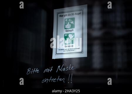 Bremen, Germany. 10th Dec, 2021. A sign on the front door of a store indicates the 2G rule. Credit: Sina Schuldt/dpa/Alamy Live News Stock Photo