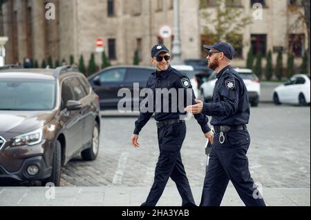 Two smiling male police officers in sunglasses
