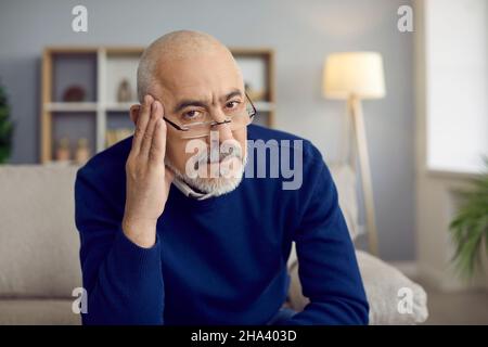 Portrait of serious senior man in glasses feeling skeptical and doubtful about your idea Stock Photo