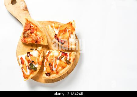 four slices of pizza on the wooden paddle or peel and a pile of toast white bread. the western food isolated on black. Stock Photo