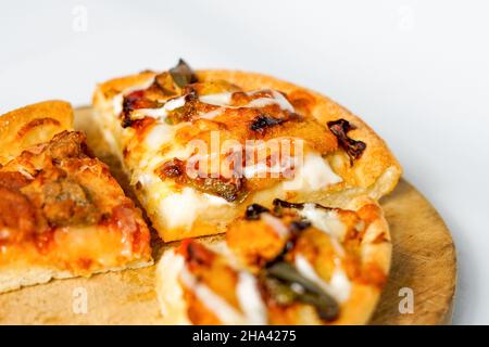 four slices of pizza on the wooden paddle or peel and a pile of toast white bread. the western food isolated on black. Stock Photo