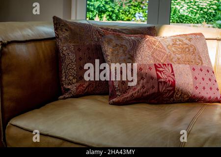 cushions on brown leather sofa Stock Photo