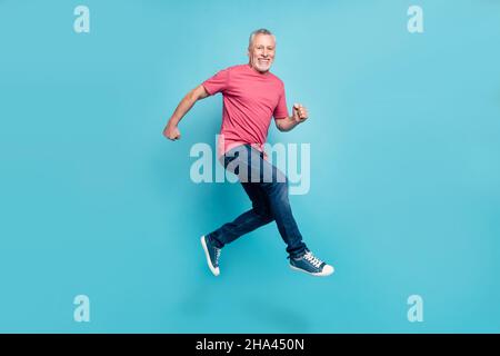 Full length body size photo smiling man jumping running fast on sale isolated pastel blue color background Stock Photo